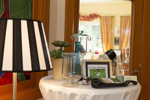 a table topped with a lamp and a table with a lamp at Hotel Garni Pölzl in Deutschlandsberg