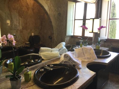 a bathroom with three sinks and a large mirror at Villa Il Padule in Bagno a Ripoli