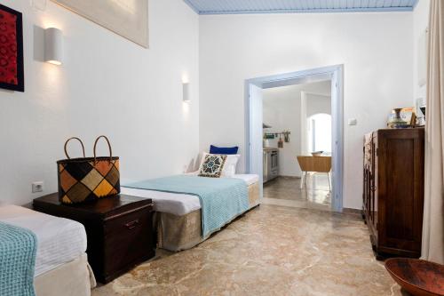 a white room with two beds and a hallway at Amelie Villa in Ixia