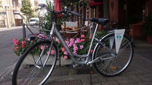 a bike parked on the side of a street with flowers at Hotel Pescetto in Albenga