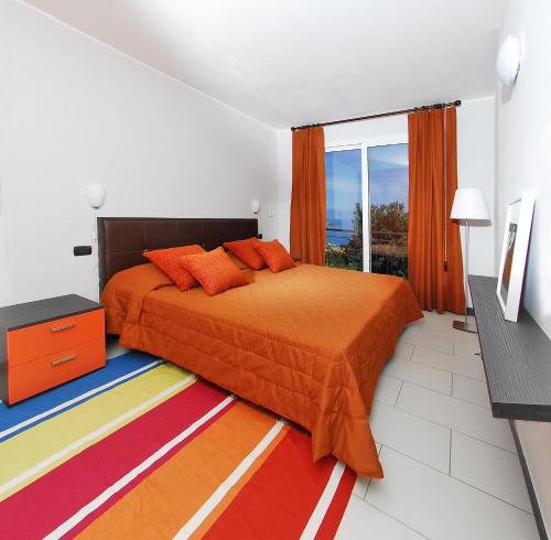 a bedroom with a orange bed and a window at Residence Villa Beuca in Cogoleto