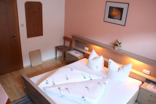 a bedroom with a large white bed with white pillows at Pension Schwemberger ohne Frühstück in Mayrhofen