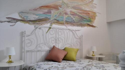 een slaapkamer met een bed met een schilderij aan de muur bij Lucrezia Garden Catania in San Gregorio di Catania