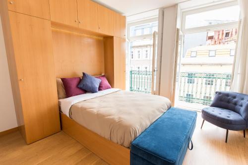 1 dormitorio con 1 cama, 1 silla y 1 ventana en Porto 271 Mouzinho Apartamentos en Oporto