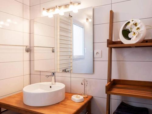 a bathroom with a sink and a mirror at Calme et Nature, BA in Gujan-Mestras