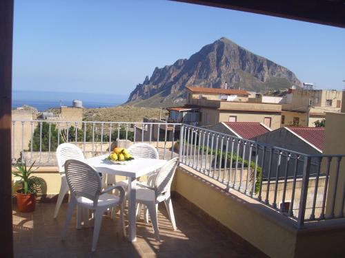 a table and chairs on a balcony with a mountain at Appartamenti Greso in Custonaci