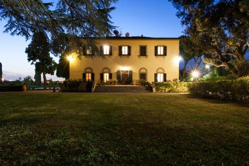 a large house with lights on in a yard at night at Villa Il Padule in Bagno a Ripoli