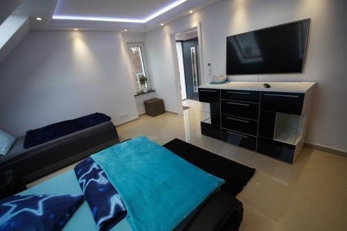 a living room with a couch and a flat screen tv at Pension / Zimmervermietung Wasbek in Wasbek