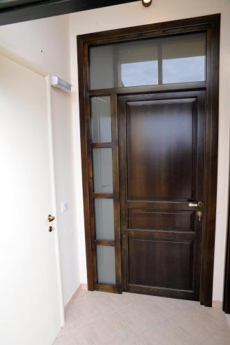a wooden door with glass panels in a room at Appartamenti Greso in Custonaci