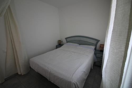 ロザスにあるGlobal Immo 2167 Franciskaの白い壁の小さな部屋の白いベッド1台