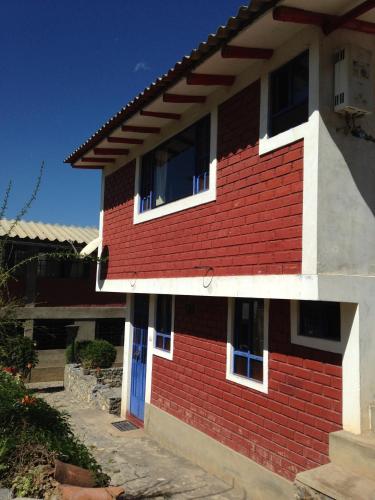 a red and white brick building with a blue door at La Casita de mi Abuela in Mancos