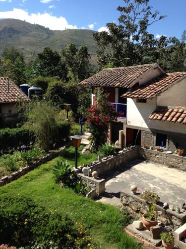 a garden in front of a house with mountains in the background at La Casita de mi Abuela in Mancos