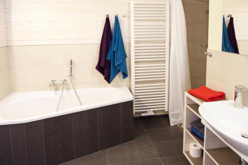 y baño con bañera y lavamanos. en Familienhotel Weimar mit Ferienwohnungen en Weimar