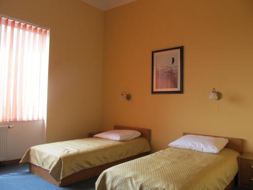 two beds in a room with a window at Noclegi Apro in Gdańsk