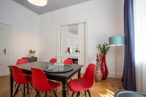 ein Esszimmer mit einem Tisch und roten Stühlen in der Unterkunft Hotel Mille Stelle City in Heidelberg