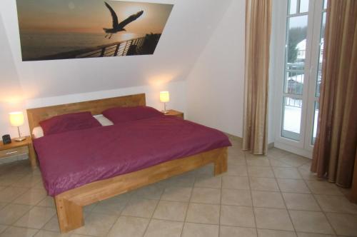 レリクにあるFerienwohnung Achterdeckのベッドルーム1室(紫のシーツが敷かれたベッド1台、頭上を飛ぶ鳥1羽付)