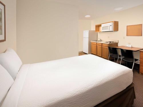 a hotel room with a bed and a kitchen at WoodSpring Suites Midland in Midland
