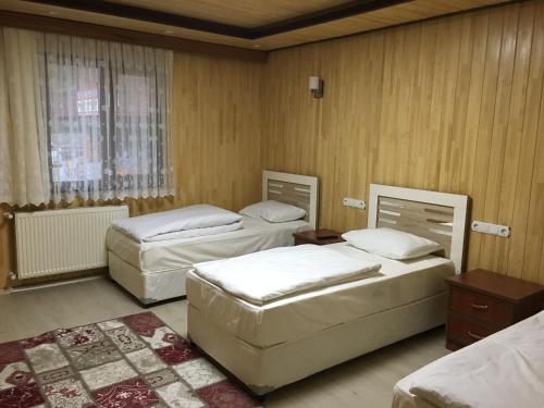 a room with three beds and a window at Kuloğlu Apart 2 in Uzungöl