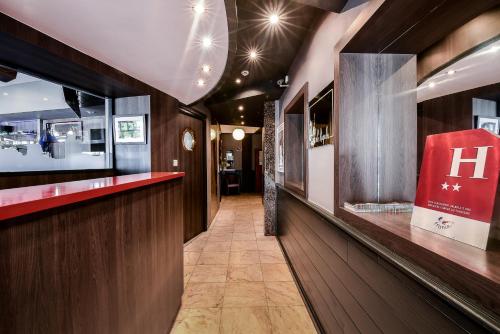 un couloir d'un restaurant avec un panneau rouge sur le mur dans l'établissement Hôtel Le Rupella, à La Rochelle