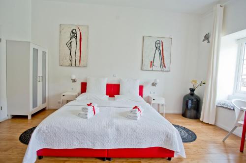 a bedroom with a large white bed with red accents at Rooms Zagreb 17 in Zagreb
