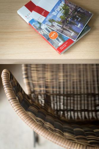 a magazine sitting on a table next to a chair at B&B Antares in Bruges