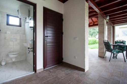 a bathroom with a shower and a toilet and a door at Apartments Jelena in Nova Vas