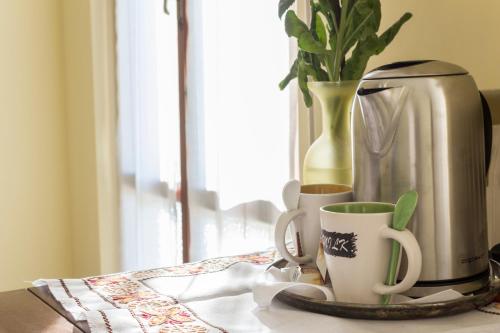 a table with two coffee cups and a vase at Camere Mariella in Bastia Umbra