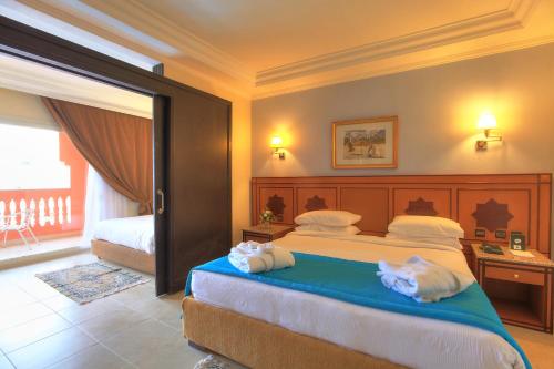 a bedroom with a large bed with towels on it at Pickalbatros Aqua Fun Club All Inclusive in Marrakech