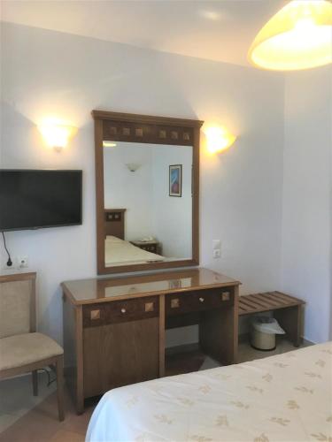 a bedroom with a desk with a mirror and a bed at Hotel Anatolia in Ano Mera