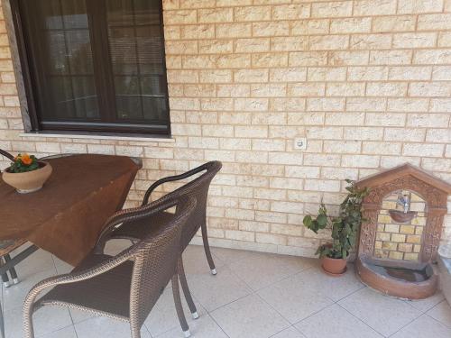 a patio with a table and chairs and a brick wall at Guest House Vaso in Órma