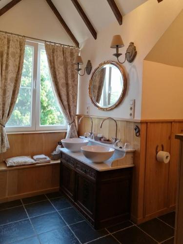 a bathroom with two sinks and a mirror at De Blauwe Maaten in Opglabbeek