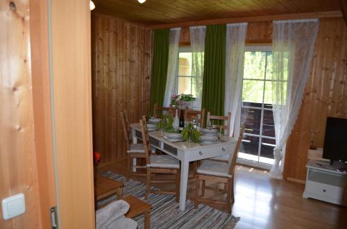 una sala da pranzo con tavolo, sedie e TV di Bauernhof König a Anger