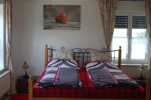 a bedroom with a bed with a red comforter at Ferienwohnung Brock in Breitenbrunn