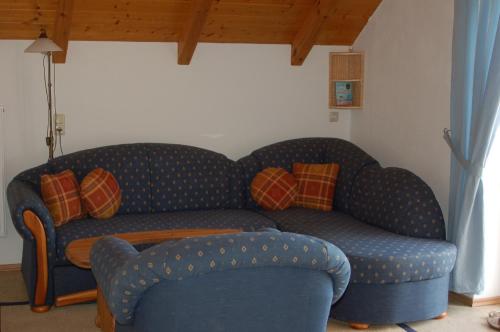 a living room with a blue couch and a chair at Ferienwohnung Brock in Breitenbrunn