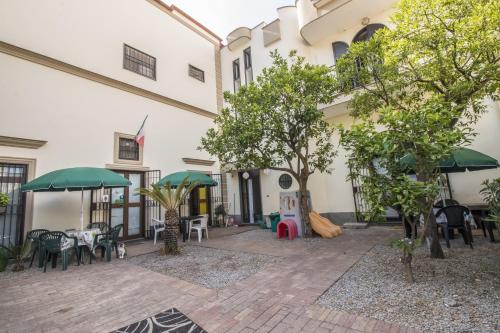 a courtyard of a building with tables and umbrellas at Due di Coppa in Scafati