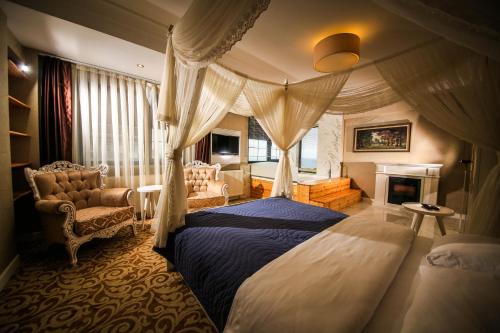 サムスンにあるMy Suit Residenceのベッドルーム(天蓋付きベッド、暖炉付)