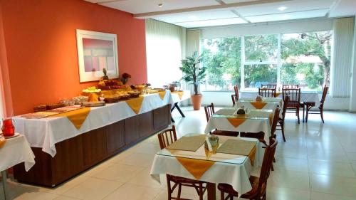 uma sala de jantar com mesas e cadeiras num restaurante em Hotel Aguadero em Passo Fundo