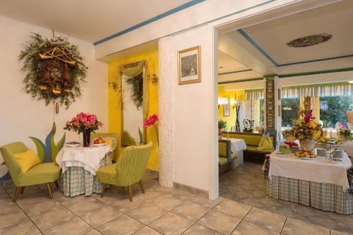 a dining room with two tables and yellow chairs at Landhaus Gastein in Seeboden
