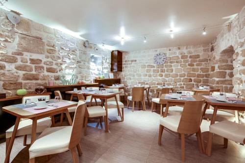 a restaurant with wooden tables and chairs and a brick wall at Hôtel de Bellevue Paris Gare du Nord in Paris
