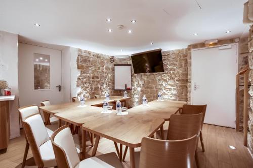 a conference room with a large wooden table and chairs at Hôtel de Bellevue Paris Gare du Nord in Paris
