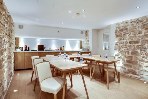 a dining room with wooden tables and white chairs at Hôtel de Bellevue Paris Gare du Nord in Paris