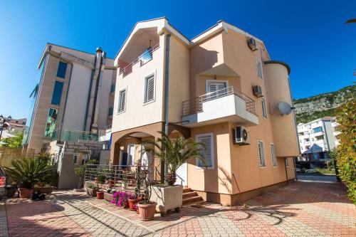 una casa grande en una calle con plantas delante en Adzic Apartments, en Budva