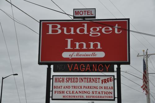 a sign for aurger inn with other signs at Budget Inn Marinette in Marinette