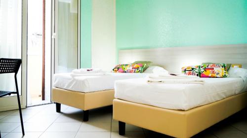 ポッツァッロにあるB&B Alta Marea Pozzalloのベッド2台が隣同士に設置された部屋です。