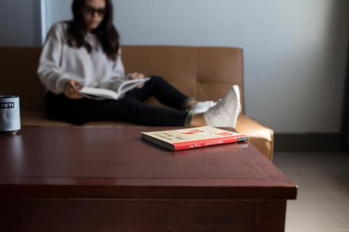 a woman sitting on a couch reading a book at La Copa Inn Beach Hotel in South Padre Island