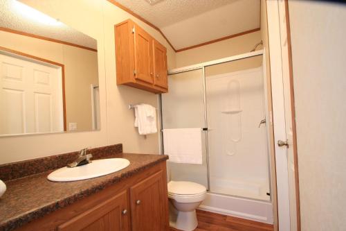 a bathroom with a sink and a toilet and a shower at Eagle Ford Village Suites in Dilley