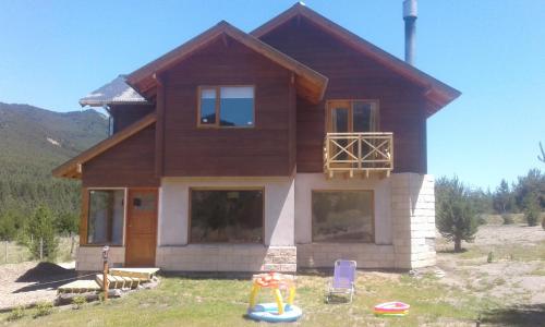 a house with a playground in front of it at Cabañas Wenuray in Villa Meliquina