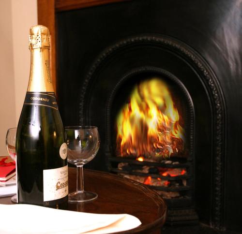 a bottle of champagne sitting on a table next to a fireplace at Crockgarve B and B in Galbally