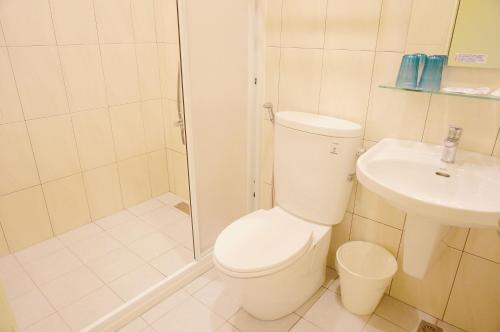 Un baño con inodoro, ducha y lavabo. en Zhuji Hostel, en Donggang