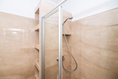 y baño con ducha y puerta de cristal. en Apartments Petra, en Dubrovnik